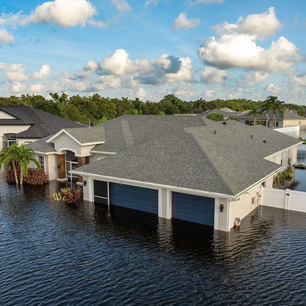 Flooded suburban home surrounded by water